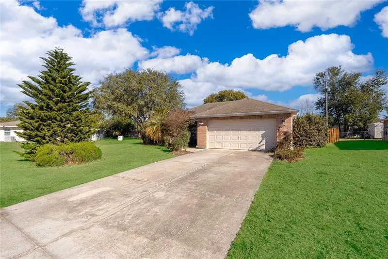 Front exterior of 794 Selby Street in Deltona: single-story home with a two-car garage on a large green lot